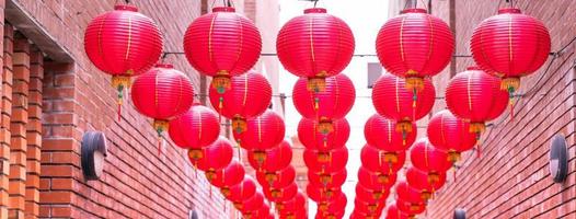 belle lanterne rouge ronde accrochée à la vieille rue traditionnelle, concept du festival du nouvel an lunaire chinois, gros plan. le mot sous-jacent signifie bénédiction. photo