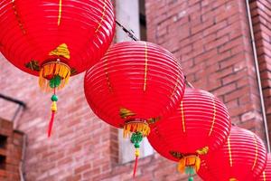 belle lanterne rouge ronde accrochée à la vieille rue traditionnelle, concept du festival du nouvel an lunaire chinois, gros plan. le mot sous-jacent signifie bénédiction. photo