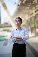 portrait de jeune belle femme d'affaires à l'extérieur. les bras croisés photo