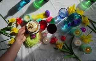 main de femme avec la pâtisserie à la levure pour pâques. ensemble de table de fête. photo