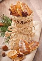 Bas de Noël en osier rempli de biscuits, bâtons de cannelle, citron confit et anis étoilé photo