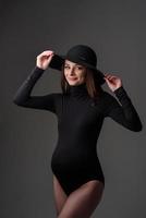 belle jeune femme enceinte en body noir et chapeau. photo