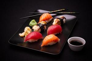 Sushi d'anguille, de saumon et de thon avec des baguettes