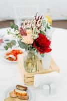 tables de dîner rondes recouvertes de tissu bleu se tiennent dans un pavillon de mariage blanc photo