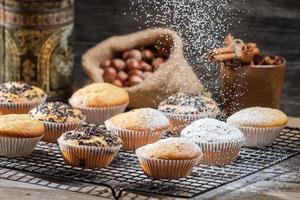 sucre en poudre tombant sur les muffins à la vanille photo