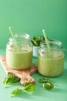 Smoothie vert sain avec banane mangue épinards dans des bocaux en verre