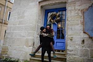 jeune couple romantique s'amuse dehors en hiver avant noël. profiter de passer du temps ensemble le soir du nouvel an. deux amants s'étreignent et s'embrassent le jour de la saint valentin. photo