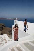 jeune couple regarde vers le bas sur le paysage de l'île de santorin photo