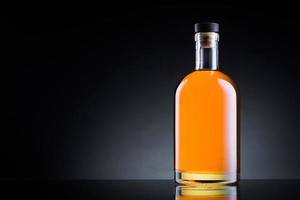 bouteille de whisky sur une surface en verre noir photo