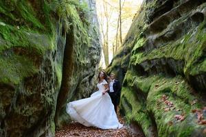 mariés. un couple se promenant dans la belle gorge étroite. la gorge était envahie de mousse verte. les jeunes mariés tournent et courent. photo