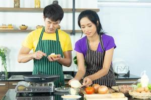 couple asiatique romantique et charmant profiter et heureux de cuisiner dans la cuisine photo