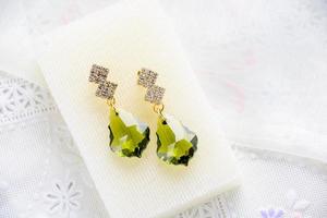 Boucles d'oreilles en cristal sur fond de tissu blanc photo