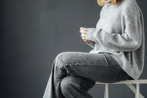 une fille avec des vêtements d'hiver en dégustant une tasse de boisson chaude pendant la saison d'hiver à la maison photo