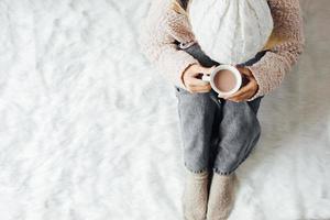 une fille avec des vêtements d'hiver en dégustant une tasse de boisson chaude pendant la saison d'hiver à la maison photo