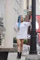 portrait de jeune fille aux cheveux bleus, adolescente debout dans la rue comme vie urbaine. photo