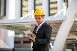 l'ingénieur et la femme d'affaires vérifient le presse-papiers sur le chantier de construction. le concept d'ingénierie, de construction, de vie urbaine et d'avenir. photo