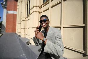 homme afro-américain s'amusant à marcher dans le centre-ville - jeune homme heureux profitant d'un coucher de soleil en plein air - mode de vie de la génération du millénaire et concept d'attitude positive des personnes photo