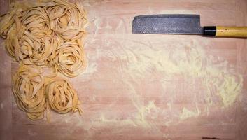 vue aérienne d'une planche à découper avec des pâtes fraîches et de la farine photo