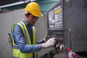 les ingénieurs de maintenance travaillent devant la réparation automatisée des machines cnc sur une liste de contrôle de maintenance sur la ligne de production. photo