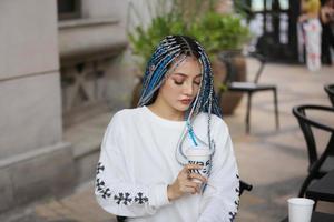 portrait de jeune fille aux cheveux bleus, adolescente debout dans la rue comme vie urbaine. photo