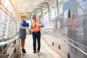 l'ingénieur et la femme d'affaires vérifient le presse-papiers sur le chantier de construction. le concept d'ingénierie, de construction, de vie urbaine et d'avenir. photo