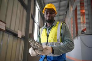 ingénieur industriel hommes portant un casque de sécurité tout en se tenant dans une usine industrielle lourde. la maintenance du travail sur des machines industrielles et la configuration du système de sécurité en usine. photo