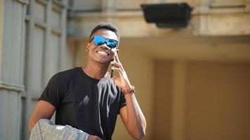 homme afro-américain s'amusant à marcher dans le centre-ville - jeune homme heureux profitant d'un coucher de soleil en plein air - mode de vie de la génération du millénaire et concept d'attitude positive des personnes photo