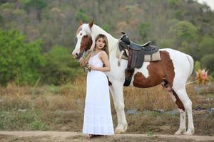 jeune femme avec son cheval dans la lumière du coucher du soleil du soir. photographie en plein air avec une fille mannequin. mode de vie photo