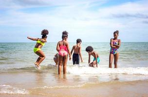 enfants jouant à courir sur le sable à la plage photo