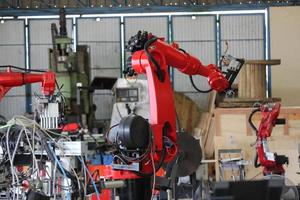 bras robotique dans l'usine métallurgique. il effectue l'entretien courant de l'équipement des unités robotiques de soudage. photo