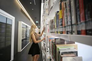 jeune femme regardant le magazine à la librairie. photo