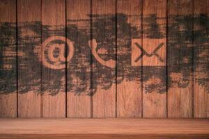 Nous contacter. icônes de téléphone, de courrier électronique et de poste peintes sur un mur en bois photo