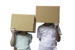 deux petite fille portant une boîte en carton sur la tête, isolée sur fond blanc.