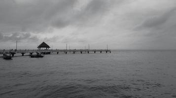 noir et blanc, photographie de paysage d'art d'une jetée avec un ciel dramatique en mer photo