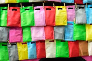 sacs en cellophane suspendus avec une corde au mur. rangée de sacs colorés suspendus. photo