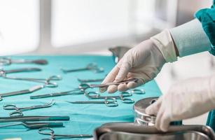 le médecin tient des instruments chirurgicaux à la main, les mains des chirurgiens avec un scalpel lors d'une opération dans la salle d'opération photo
