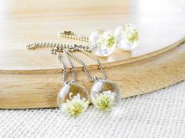 fleur séchée en collier pendentif en résine cristalline, pendentif avec de vraies fleurs. photo