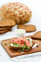 sandwich au saumon fumé avec fromage, pistaches et feuilles de salade, pains bruns