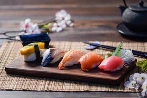 mélanger les sushis sur un plat en bois, thon, saumon, bar, œuf sucré, sushis aux crevettes, cuisine japonaise photo