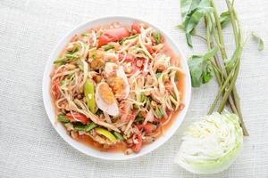 salade de papaye avec œufs salés, piments pilés et ail, puis placez des tranches de tomate, d'aubergine et d'œuf salé. ajouter la sauce de poisson, le citron, le sucre, la papaye hachée puis mélanger tous les ingrédients ensemble. photo