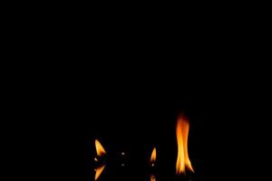 flammes de feu nature sur fond noir. figer le mouvement des flammes de feu rouge-jaune brûlant dans la nuit noire. photo