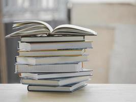 une composition simple de nombreux livres, pile ou pile de livres sur une table en bois, l'un d'eux ouvert avec espace de copie. photo