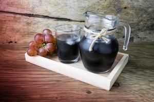 raisins frais et jus sur table en bois photo