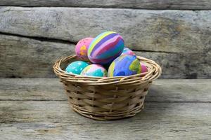 oeufs de pâques dans le panier sur bois photo