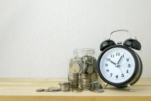 horloge et piles de pièces pour le concept d'argent d'entreprise photo