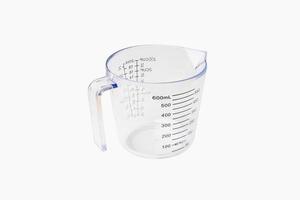 tasse à mesurer graduée en plastique transparent vide ou verre doseur sur fond blanc photo