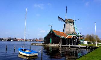 Moulins à vent antiques et rivière et bateau en Hollande, Pays-Bas, Europe photo