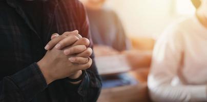 jeune homme priant crise chrétienne à dieu priant pour les bénédictions de dieu pour une vie meilleure. avec les membres de l'église qui acceptent Dieu photo