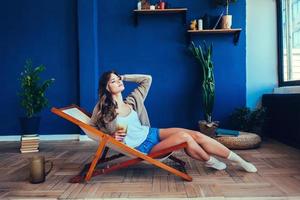 femme à la maison assise sur une chaise moderne photo