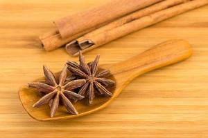 étoiles d'anis dans une cuillère en bois avec un bâton de cannelle photo